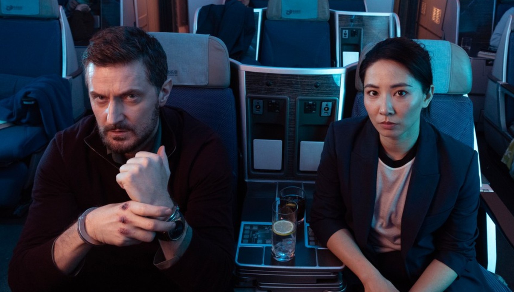 Richard Armitage and Jing Lusi sitting on an aeroplane in Red Eye