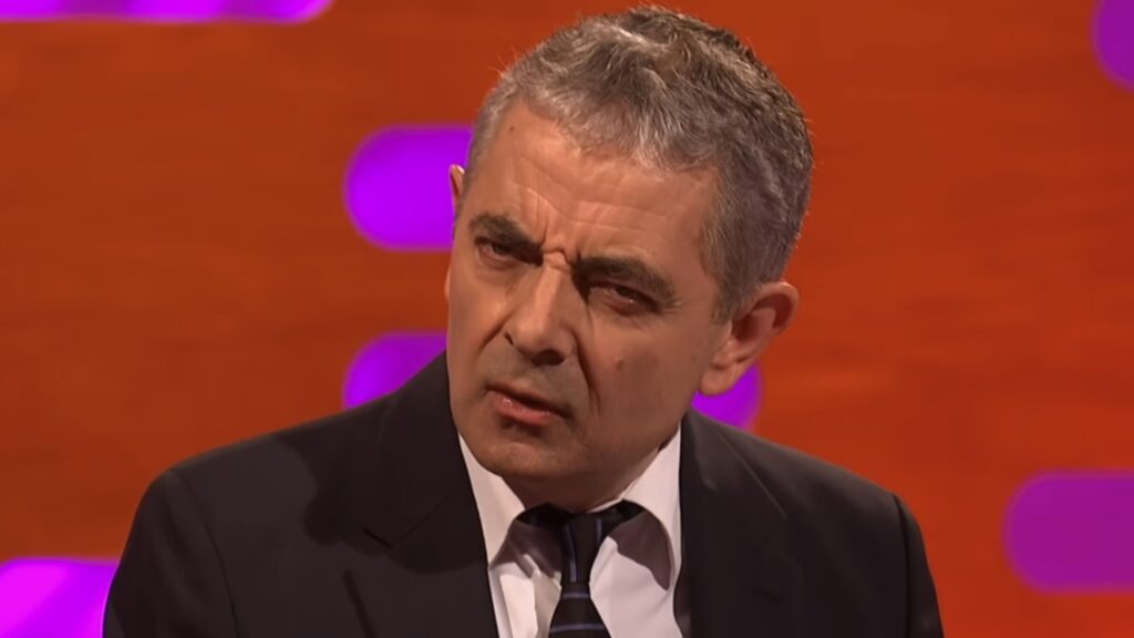 Rowan Atkinson with a serious, confused look on his face on The Graham Norton Show