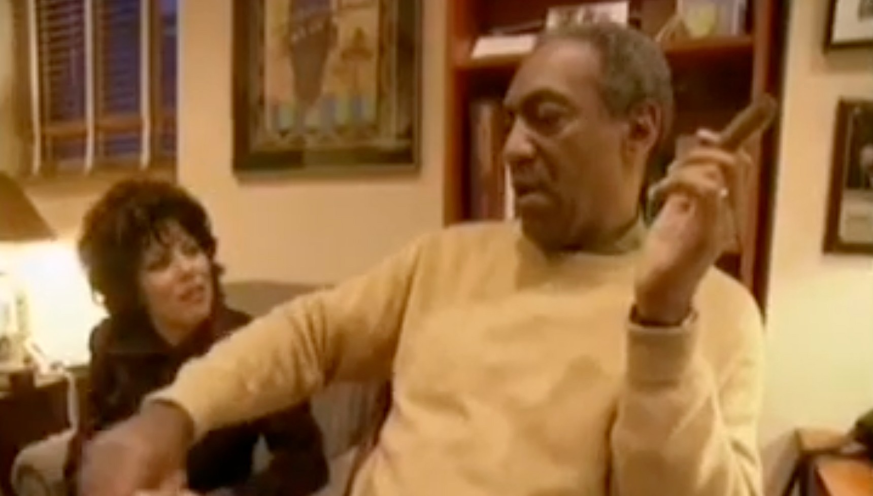 Bill Cosby holding a cigar next to Ruby Wax 