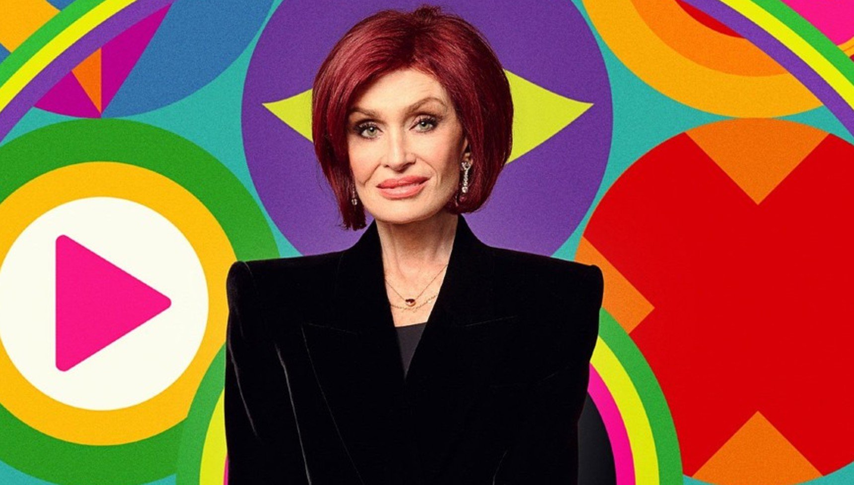 Sharon Osbourne in a black suit with red hair