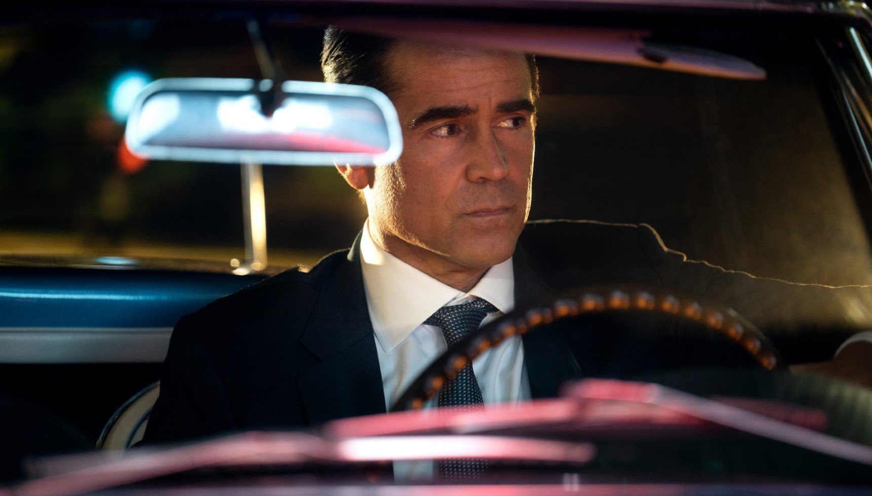 Suited man driving at night