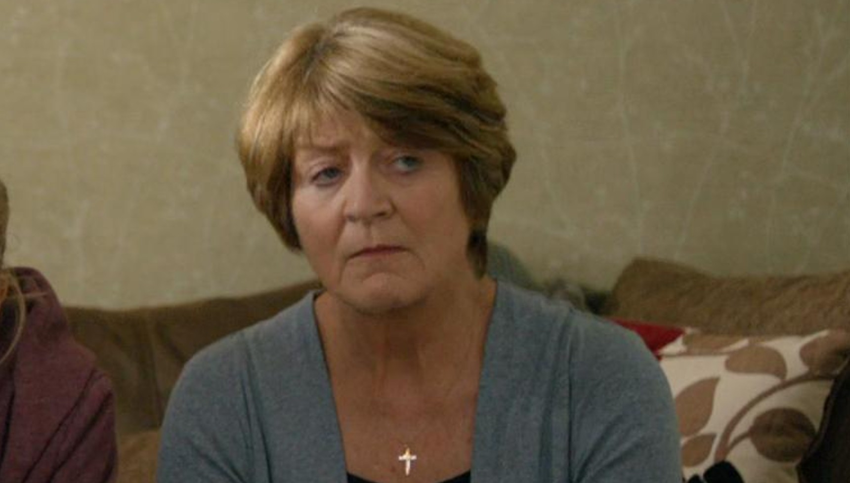 Susan Brown sitting on a sofa in Broadchurch