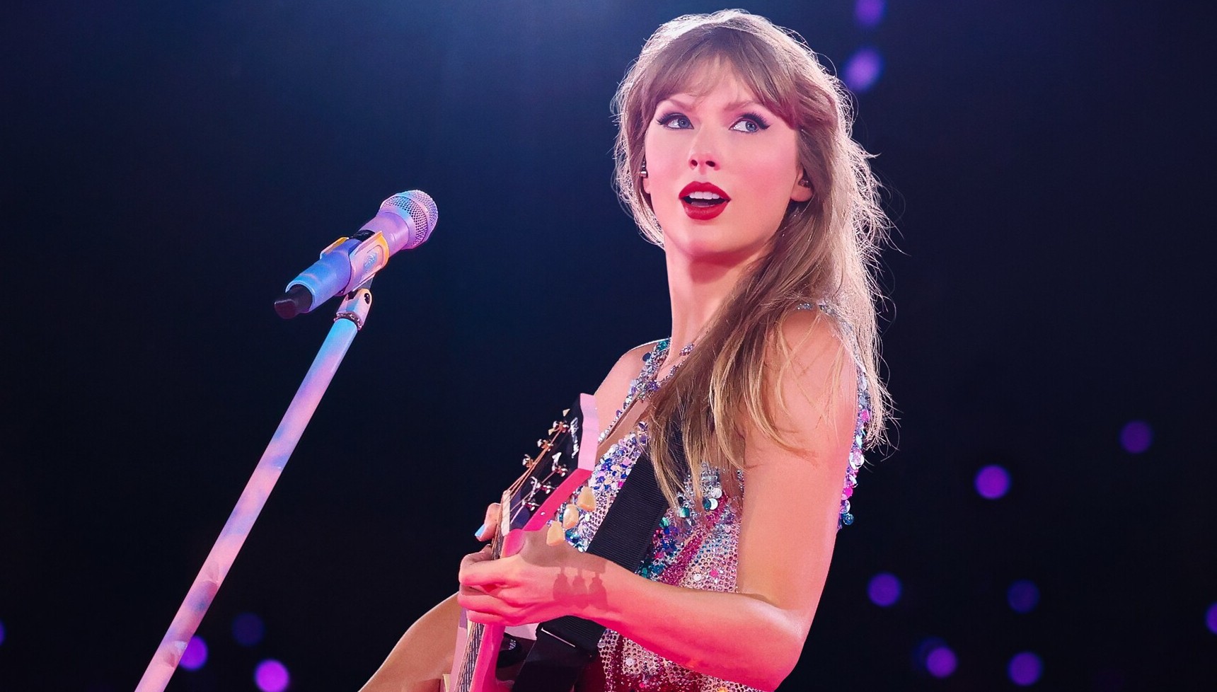 Taylor Swift playing guitar during the Eras Tour