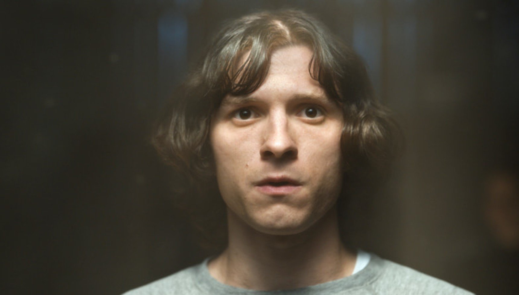 A long-haired young man looking worried