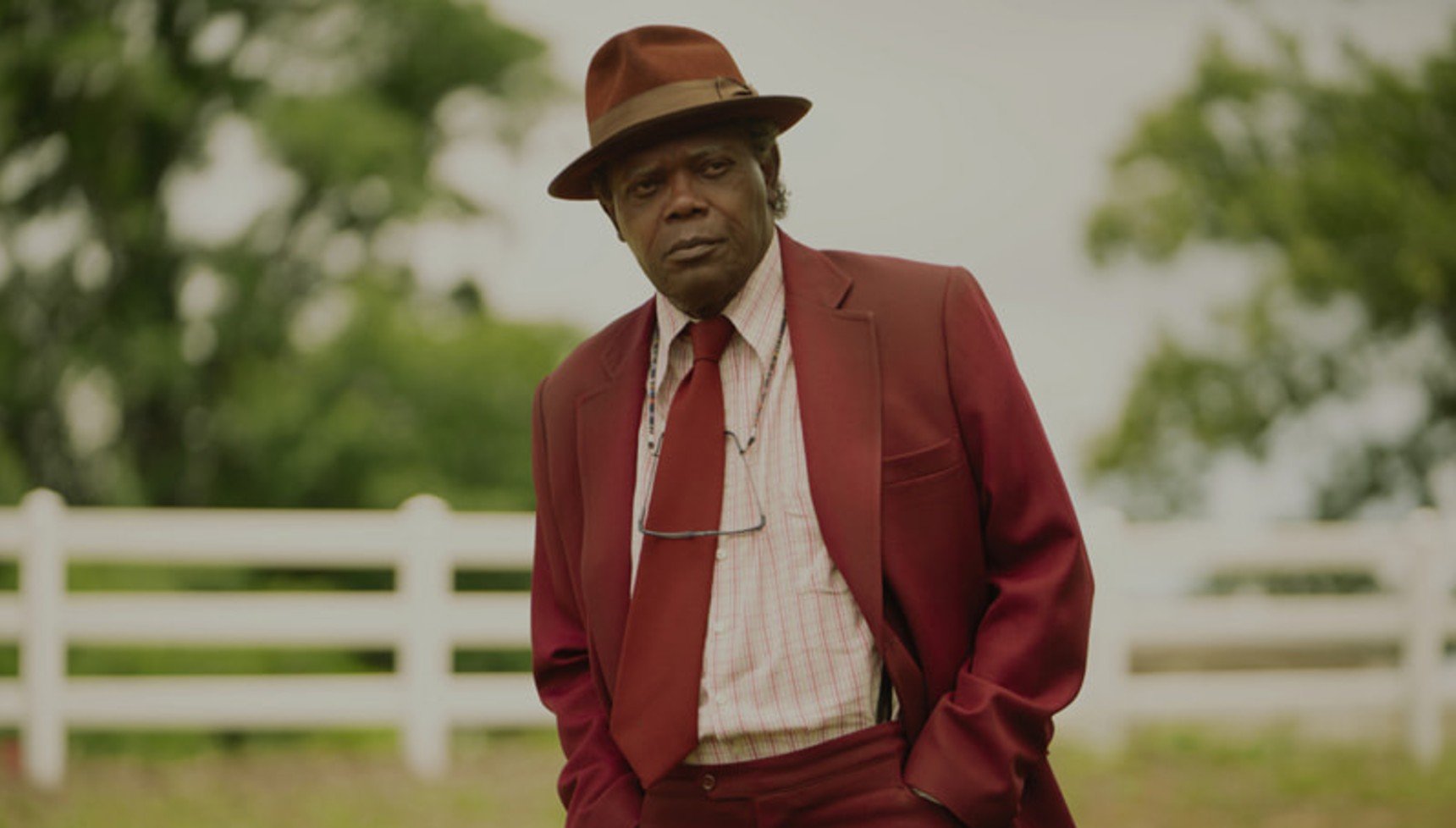Man in a red suit standing in a garden