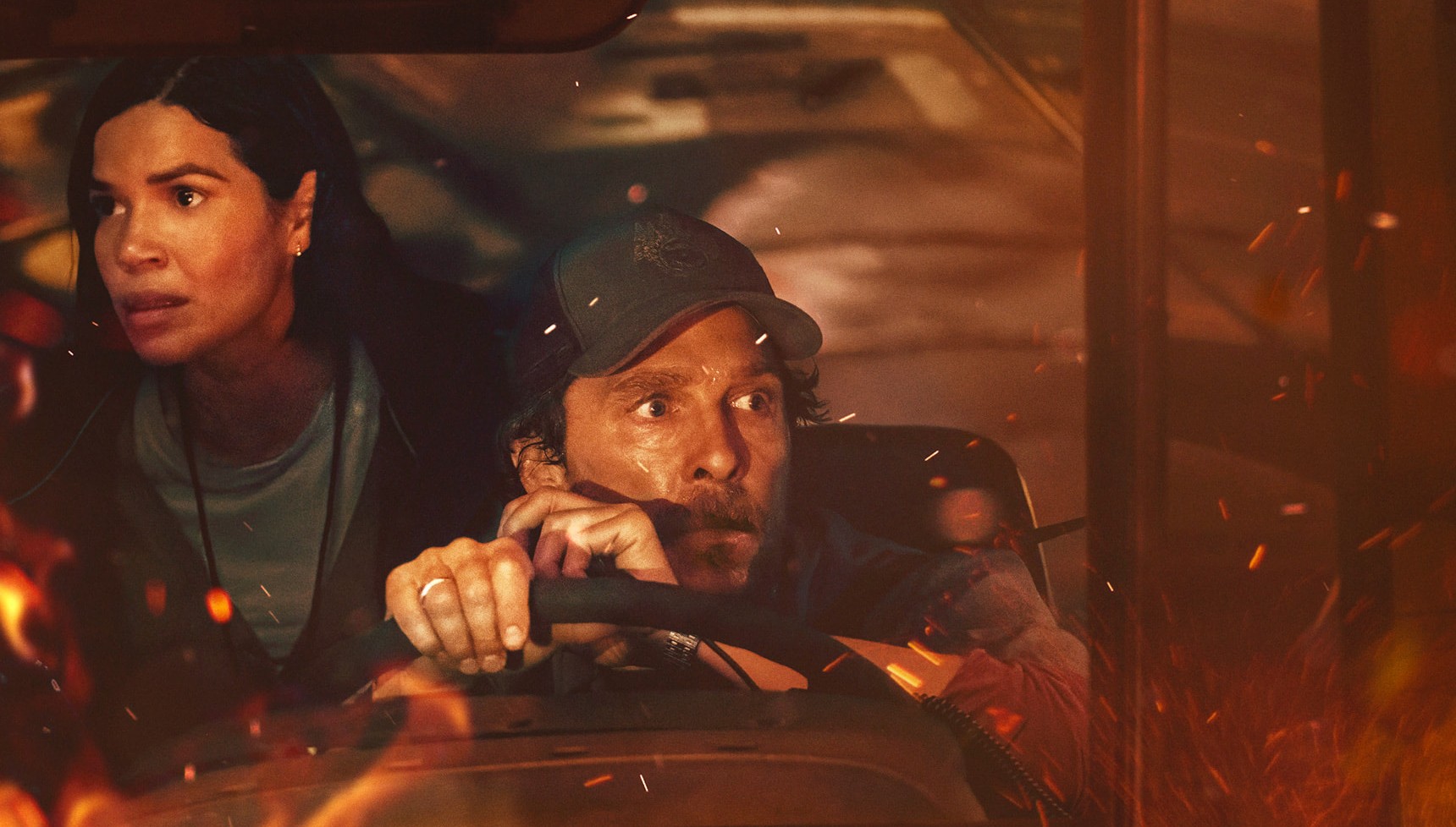 A bus driver and a woman look at the fires enveloping their vehicle