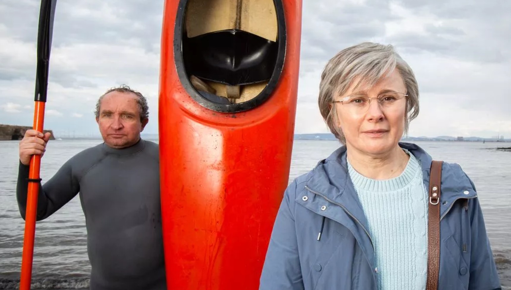 Eddie Marsan in a wetsuit next a canoe and Monica Dolan