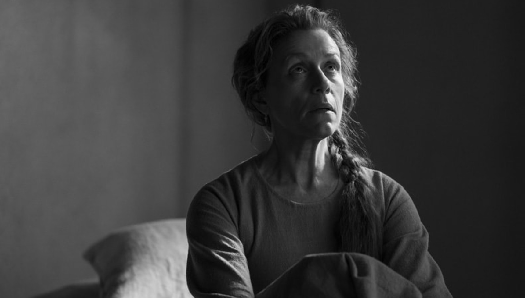 A woman in black-and-white looks upwards