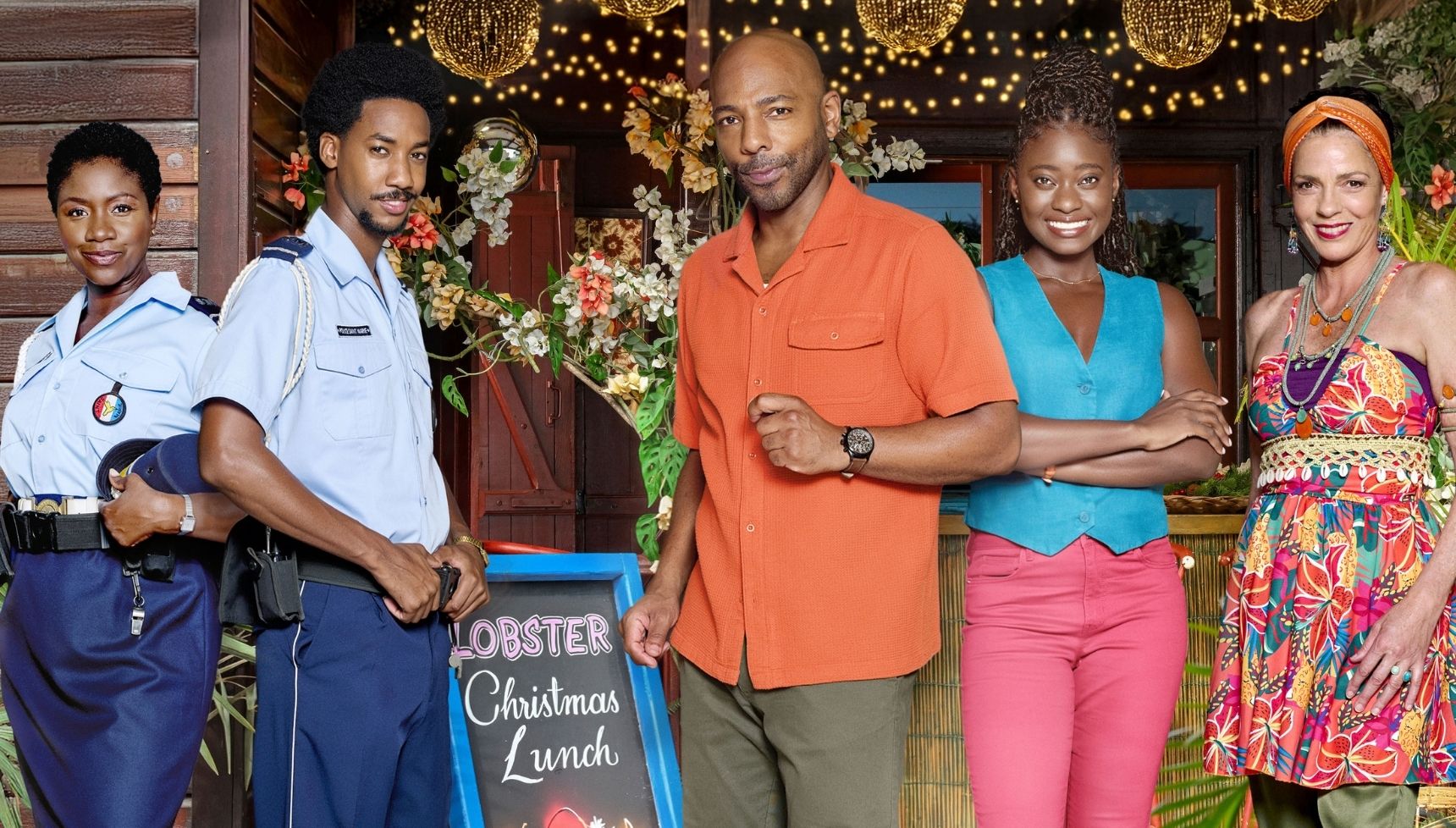 The Death in Paradise cast in a group shot for the Christmas Special - L-R: Darlene, Seb Rose, Mervin, Naomi and Catherine