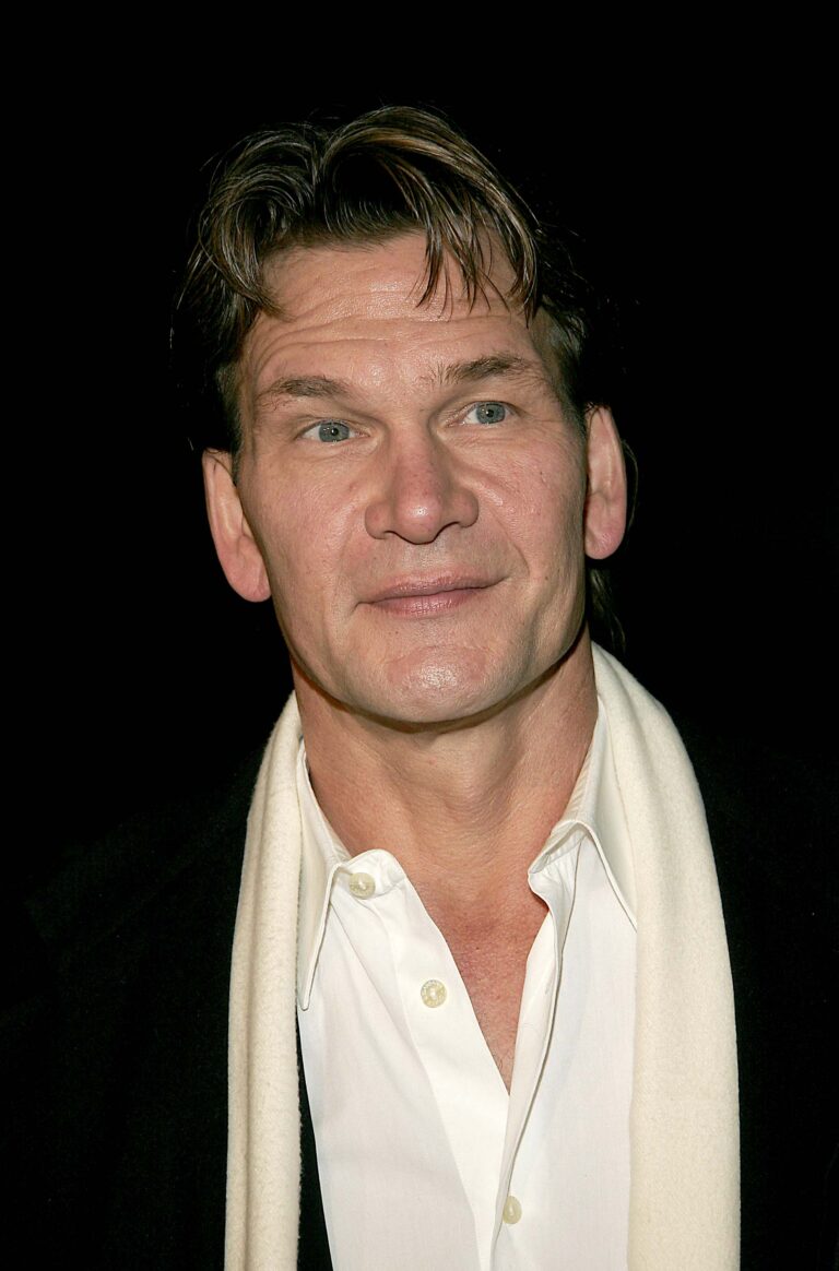 Patrick Swayze wears a suit and scarf