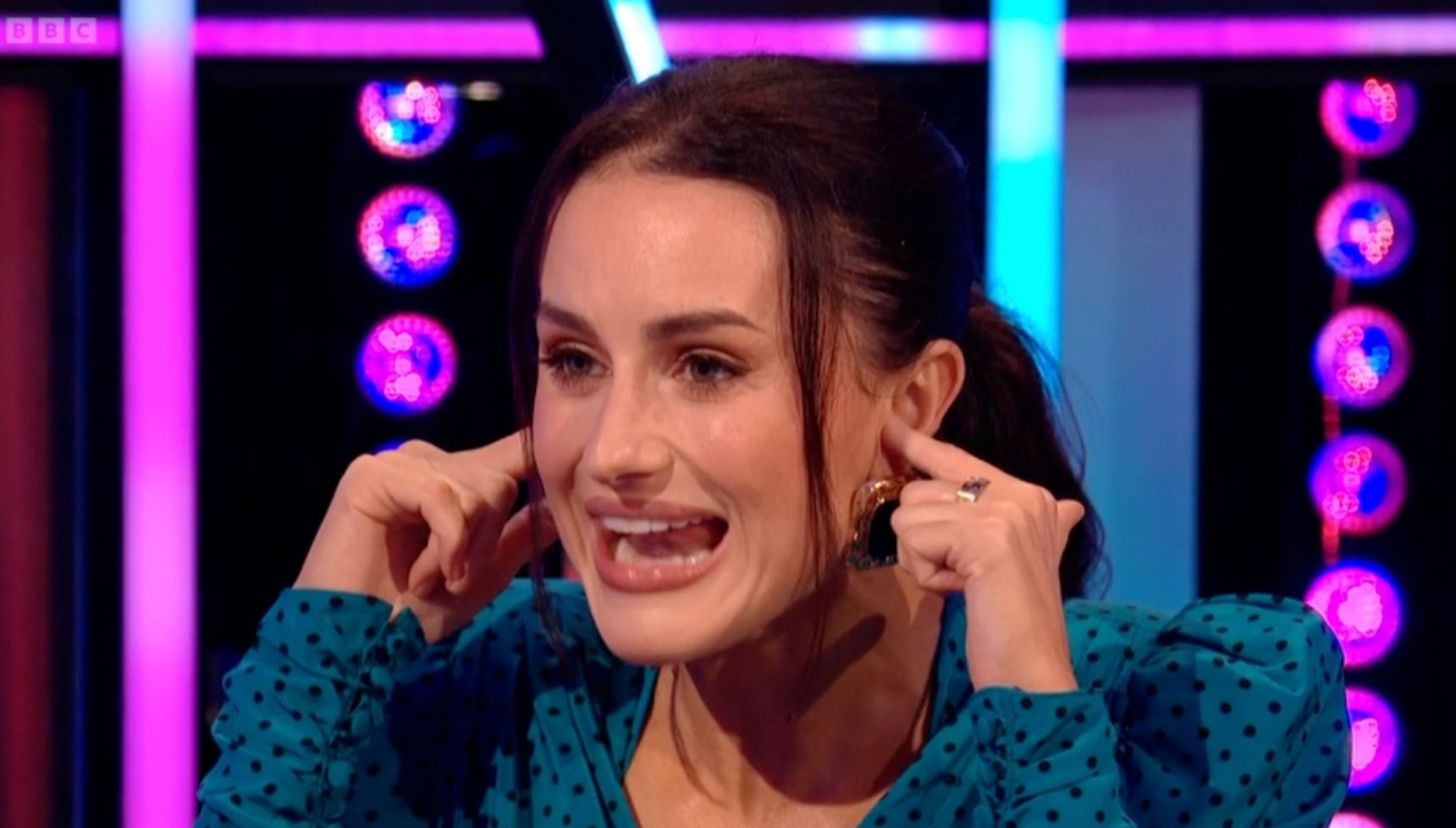 Amber holding her ears on It Takes Two