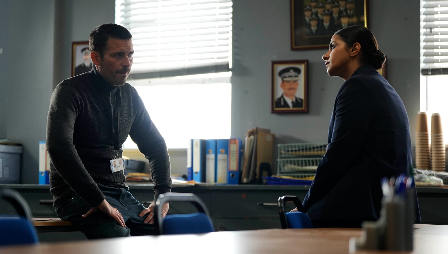 Ben Cooper and Diane Fry sit across from each other in Cooper & Fry