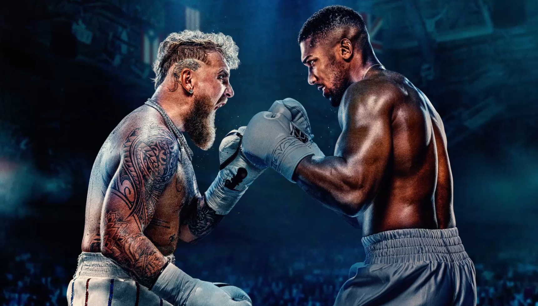 Jake Paul holding his boxing gloves up to Anthony Joshua