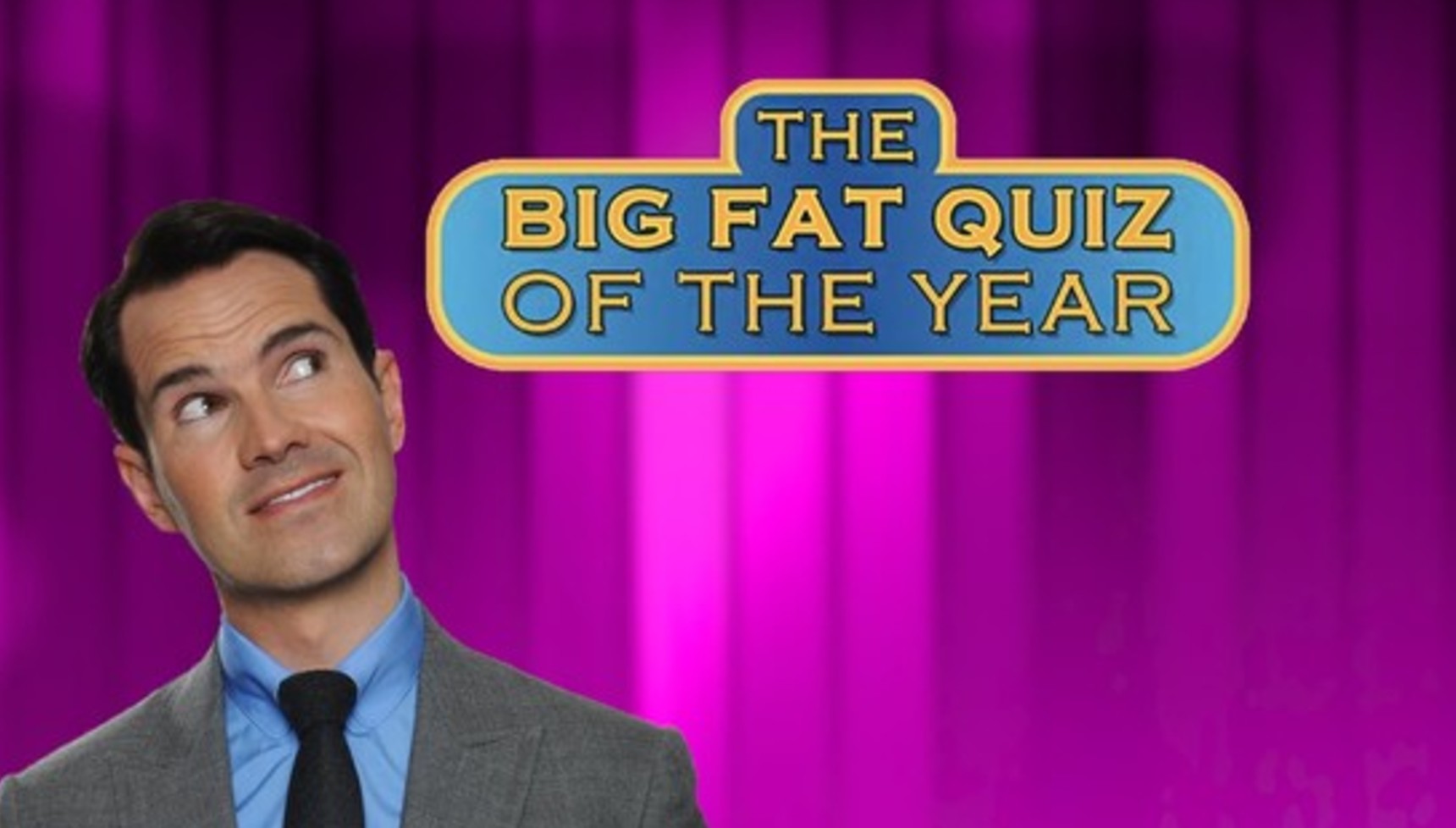 Jimmy Carr looking at The Big Fat Quiz of the Year logo