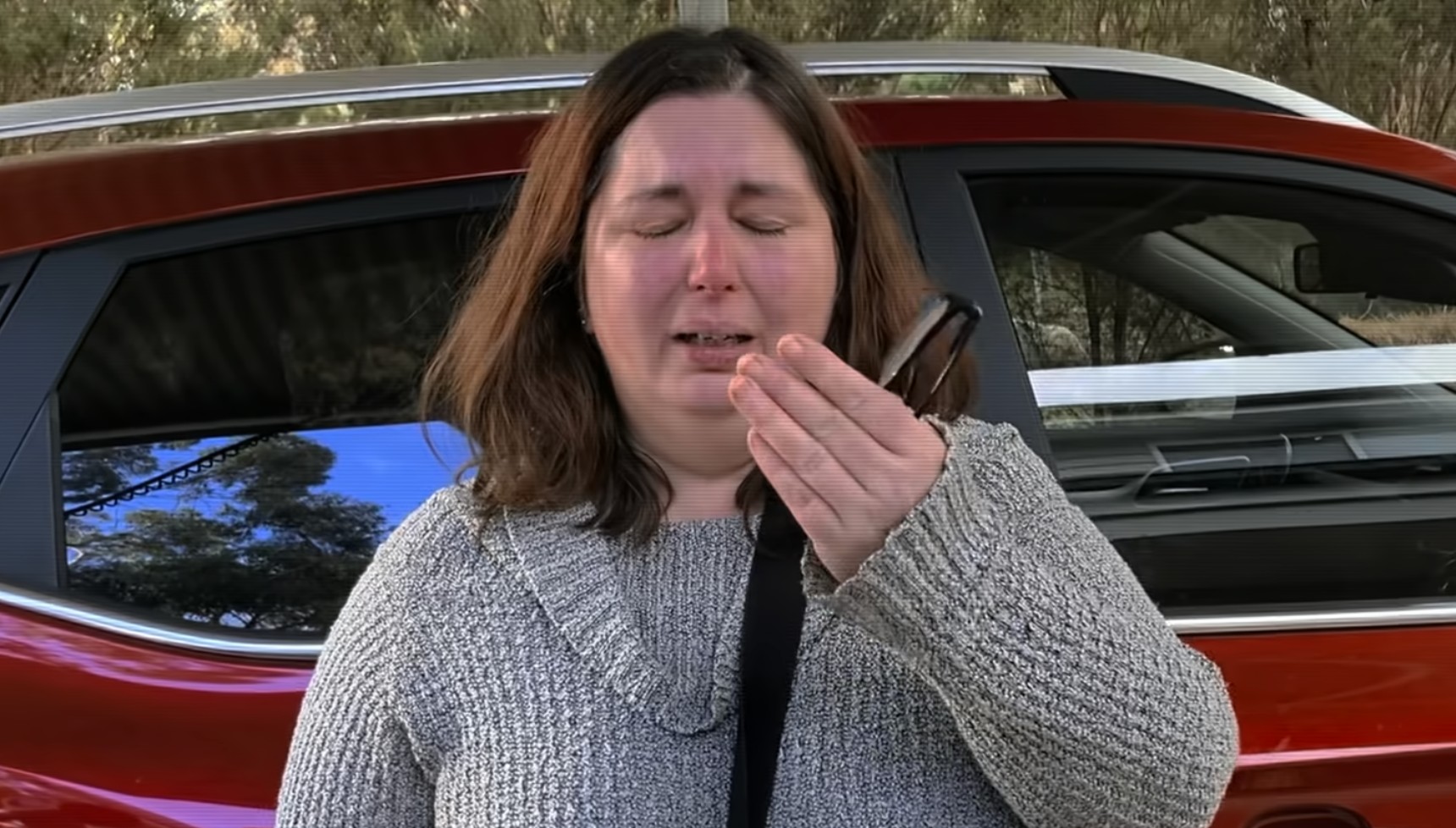 Erin Patterson crying in front of her car