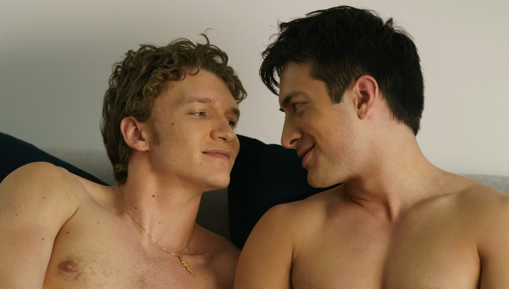 Ilya (Connor Storrie) and Shane (Hudson Williams) looking at each other in bed in Heated Rivalry