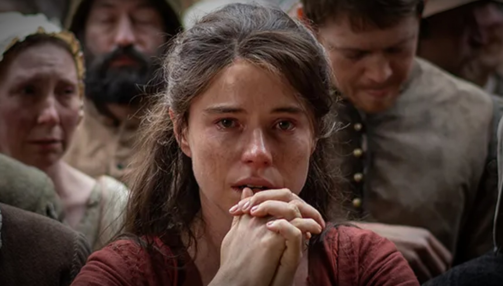 Jessie Buckley holding her hands together in Hamnet 