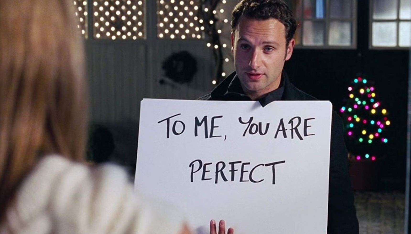 Andrew Lincoln holding a card that says "To me, you are perfect" in Love Actually