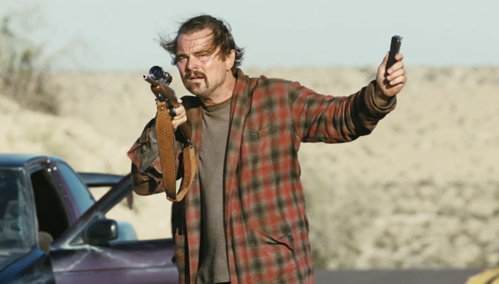 Leonardo DiCaprio holding a rifle in One Battle After Another