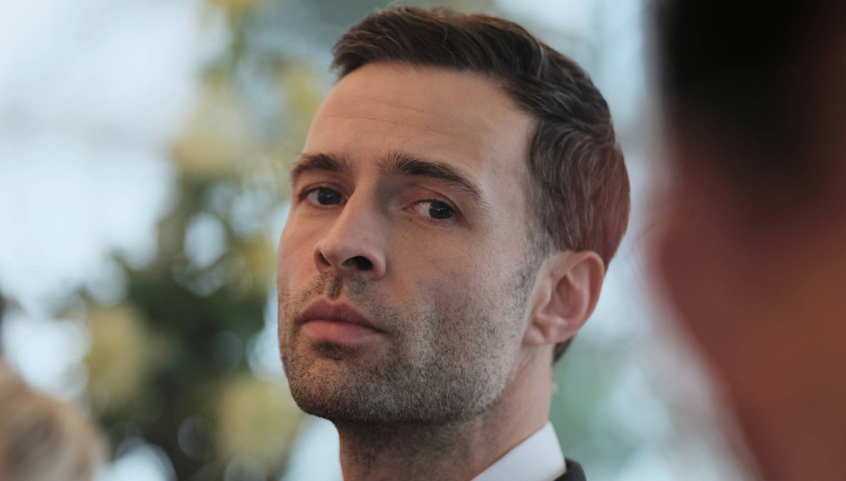 Close up of killer at the US Embassy party in Red Eye series 2