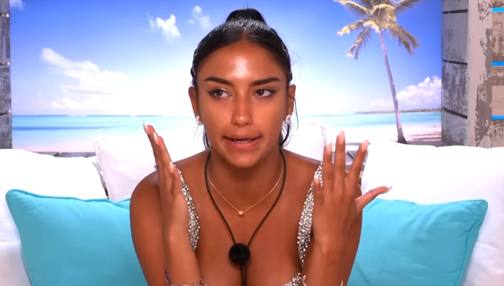 Shakira holding her hands up in Love Island 