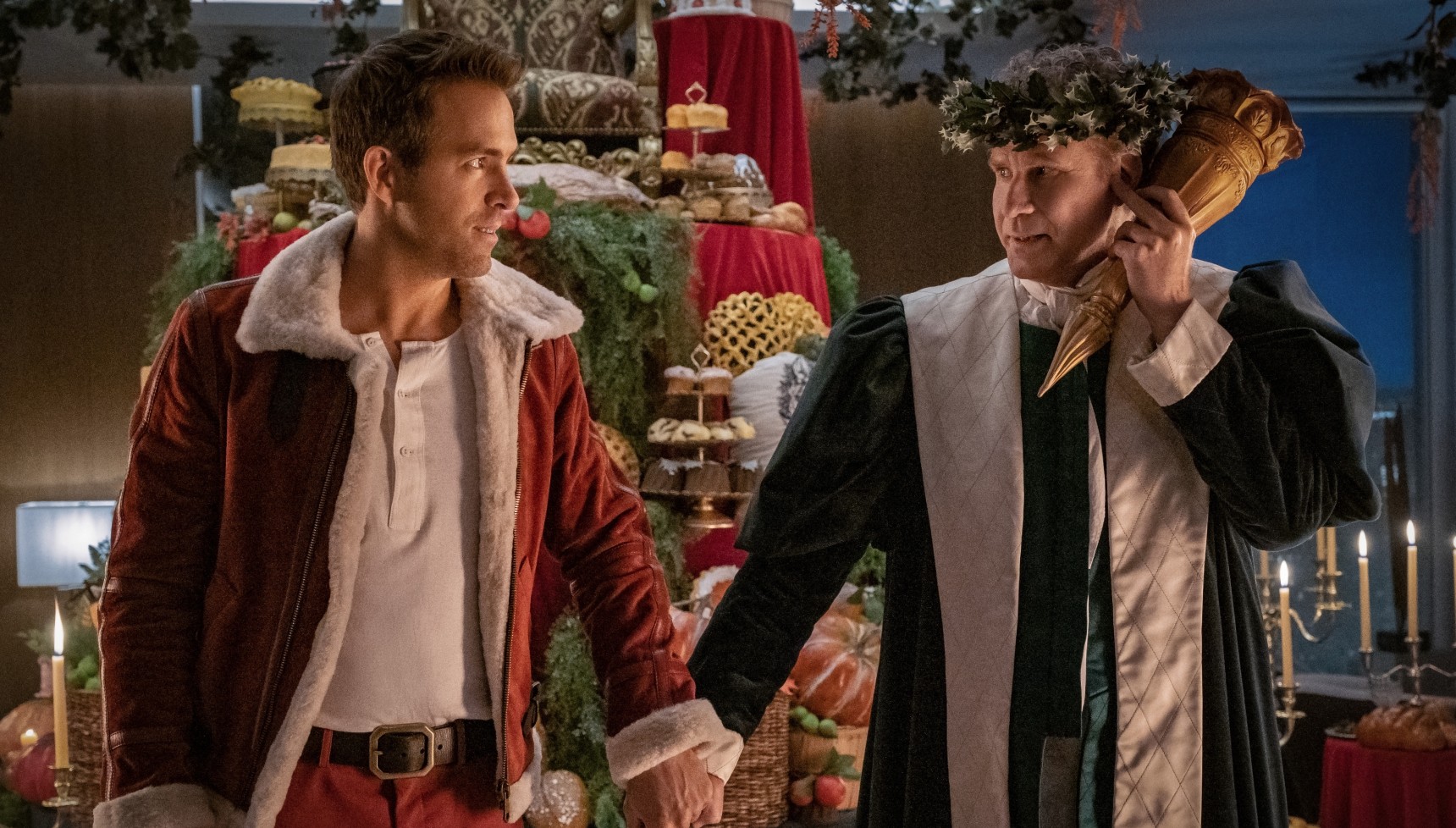 Ryan Reynolds standing next to Will Ferrell dressed as the Ghost of Christmas Present in Spirited