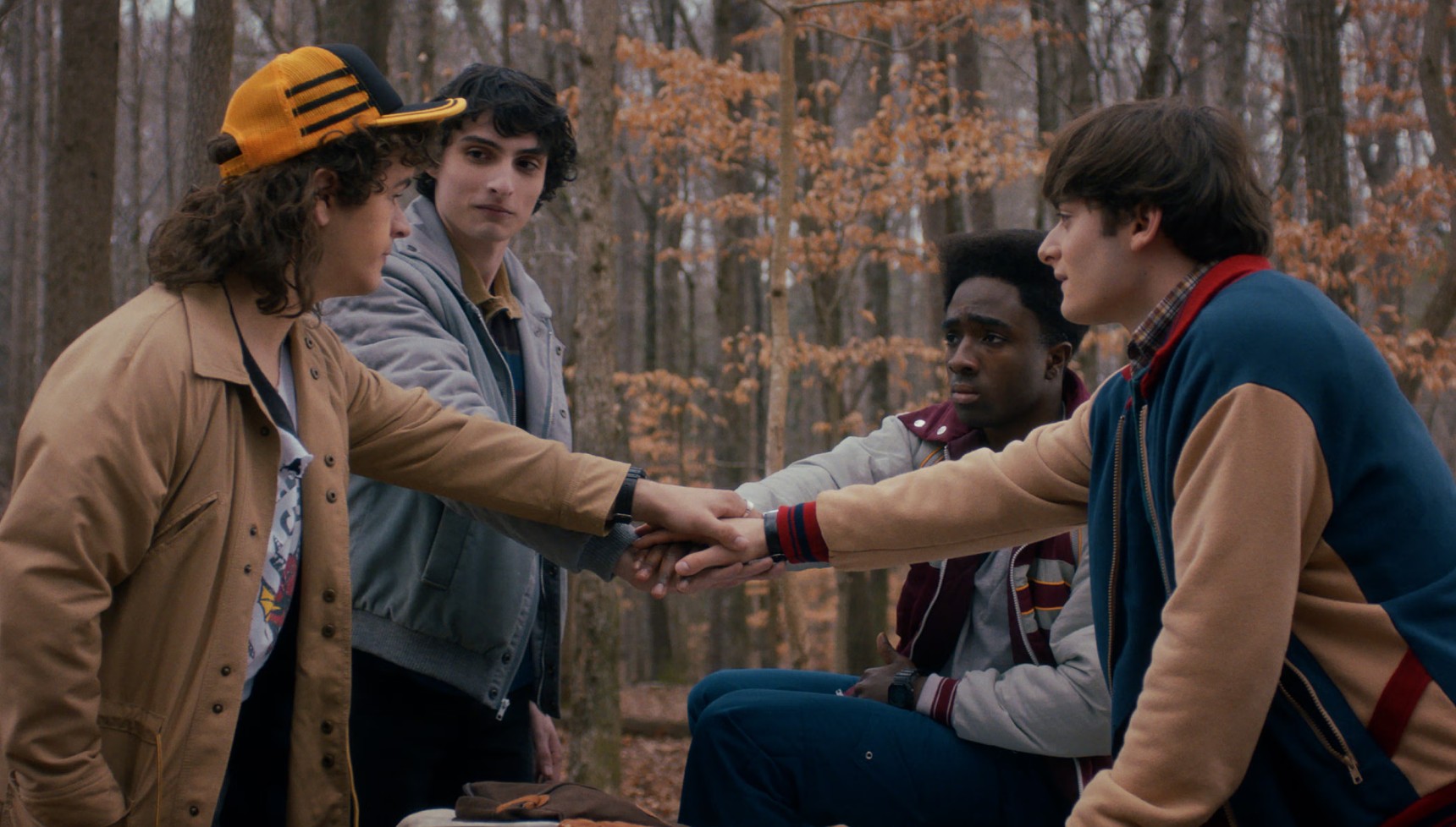 Dustin, Mike, Lucas, and Will shaking hands in Stranger Things season 5