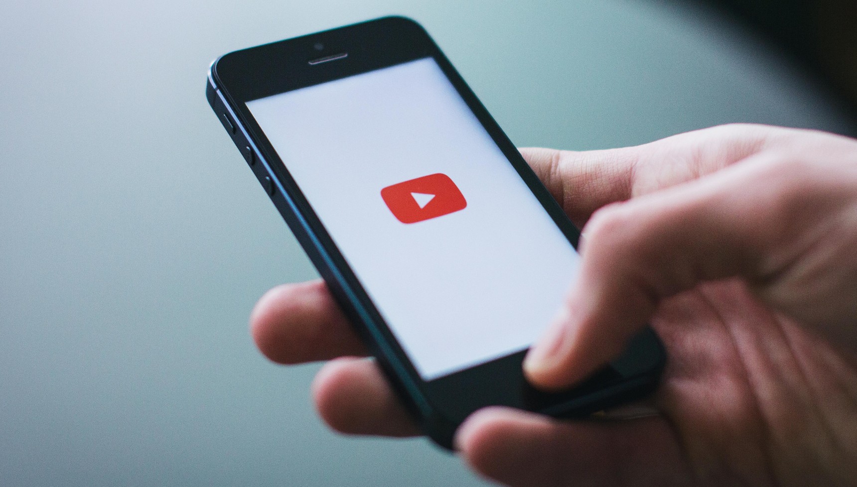 Someone opening the YouTube app on their smartphone