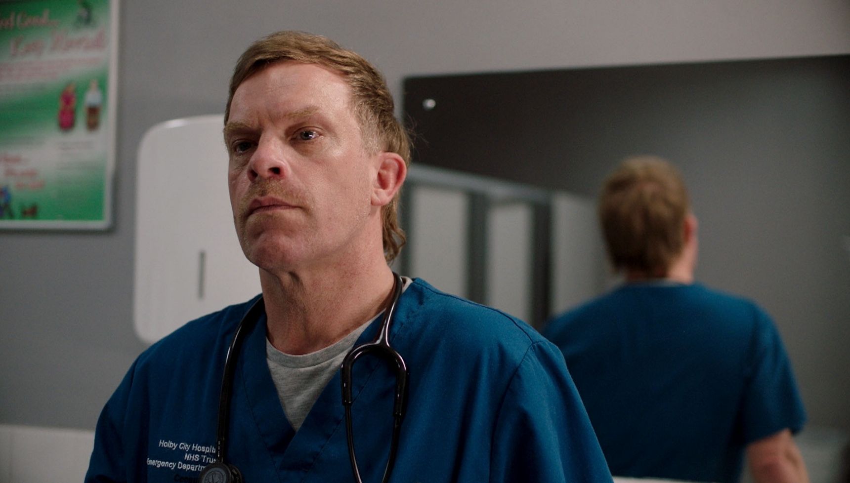 Dylan looking worried in a hospital toilets in Casualty