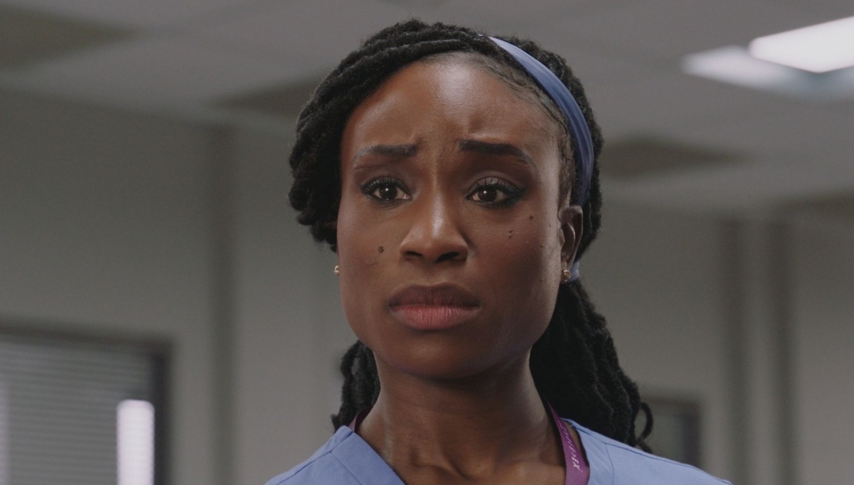 Ngozi Okoye looking worried in blue scrubs
