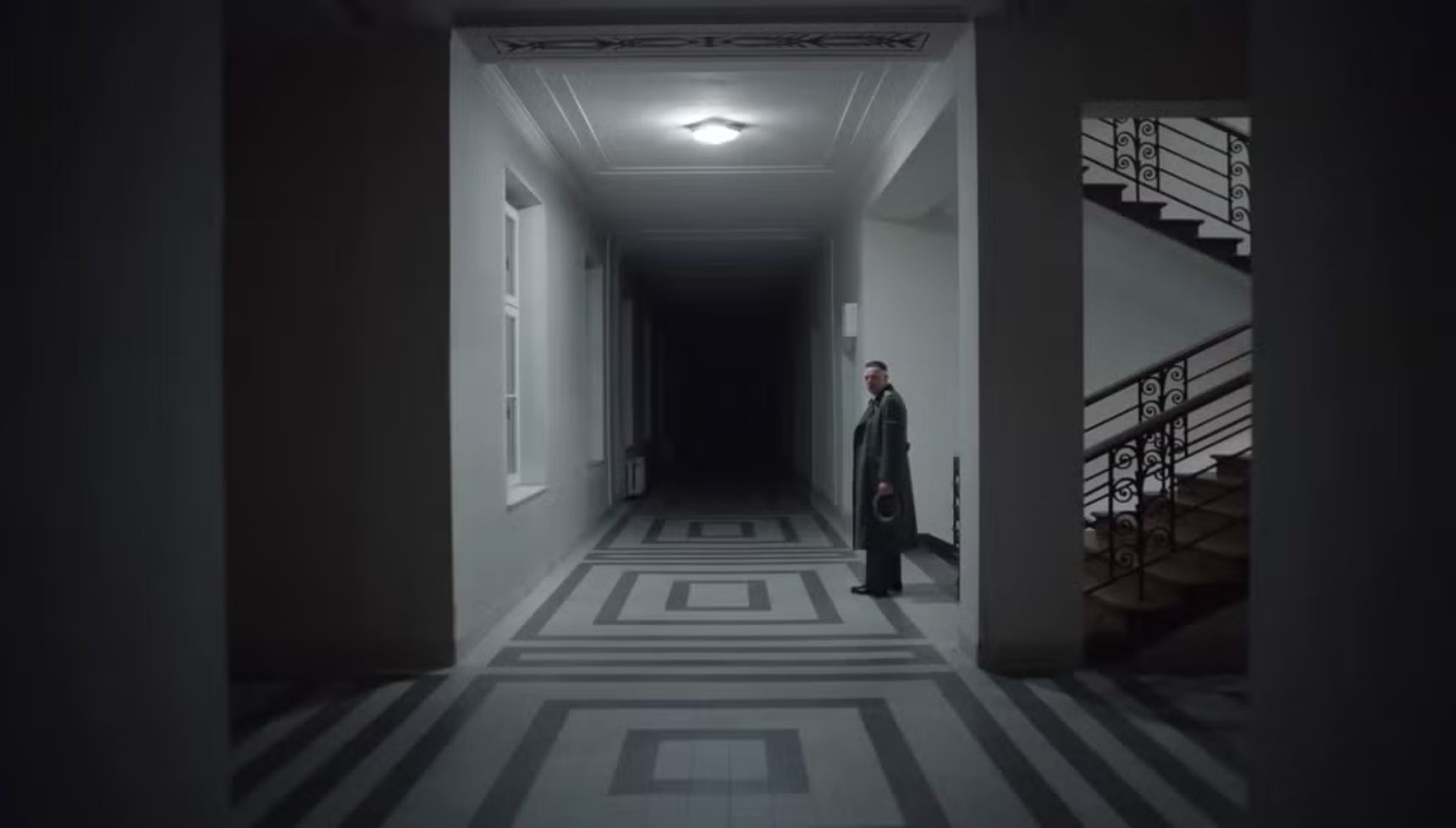 A Nazi soldier standing in a hallway alone in The Zone of Interest