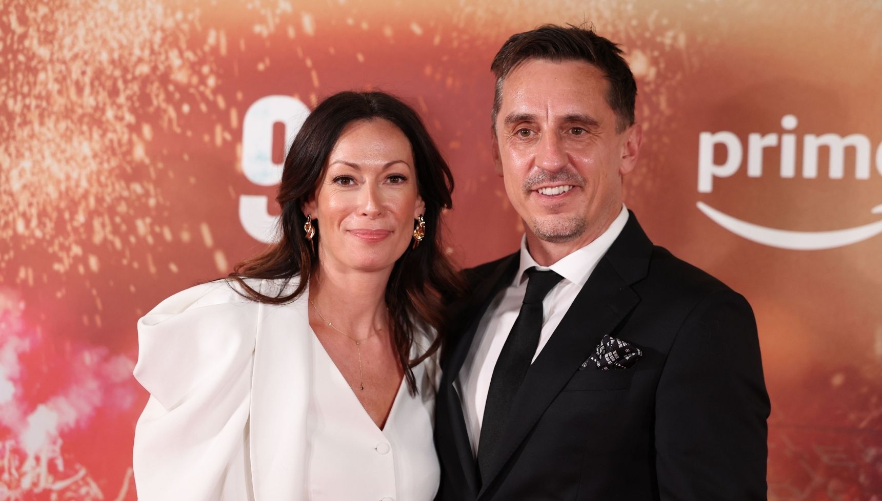 Gary Neville and his wife Emma smiling at event