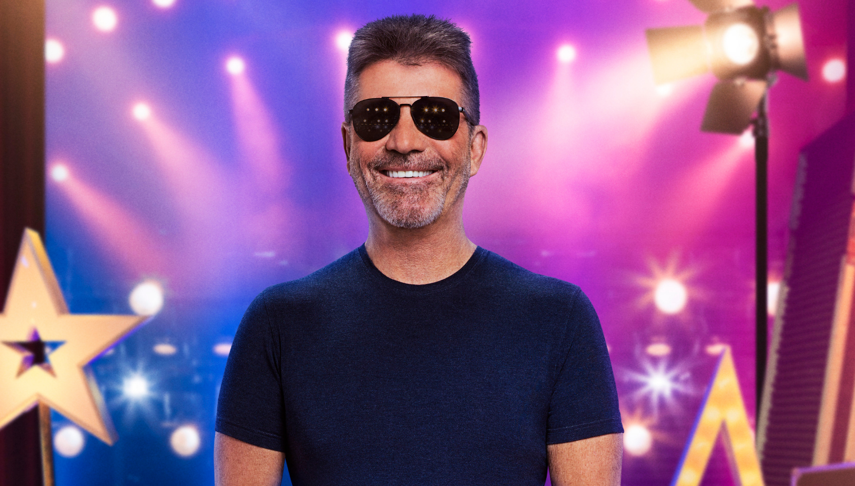 Simon Cowell smiling in sunglasses