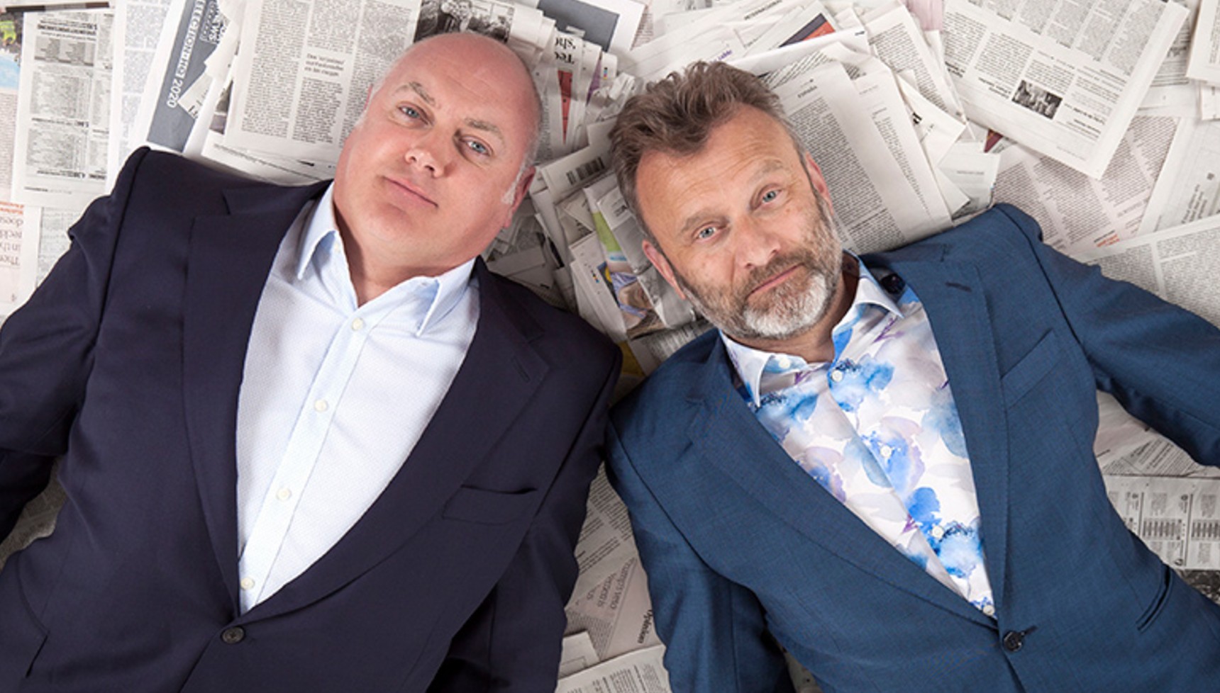 Dara Ó Briain and Hugh Dennis lying on newspapers in a promotional image for Mock the Week