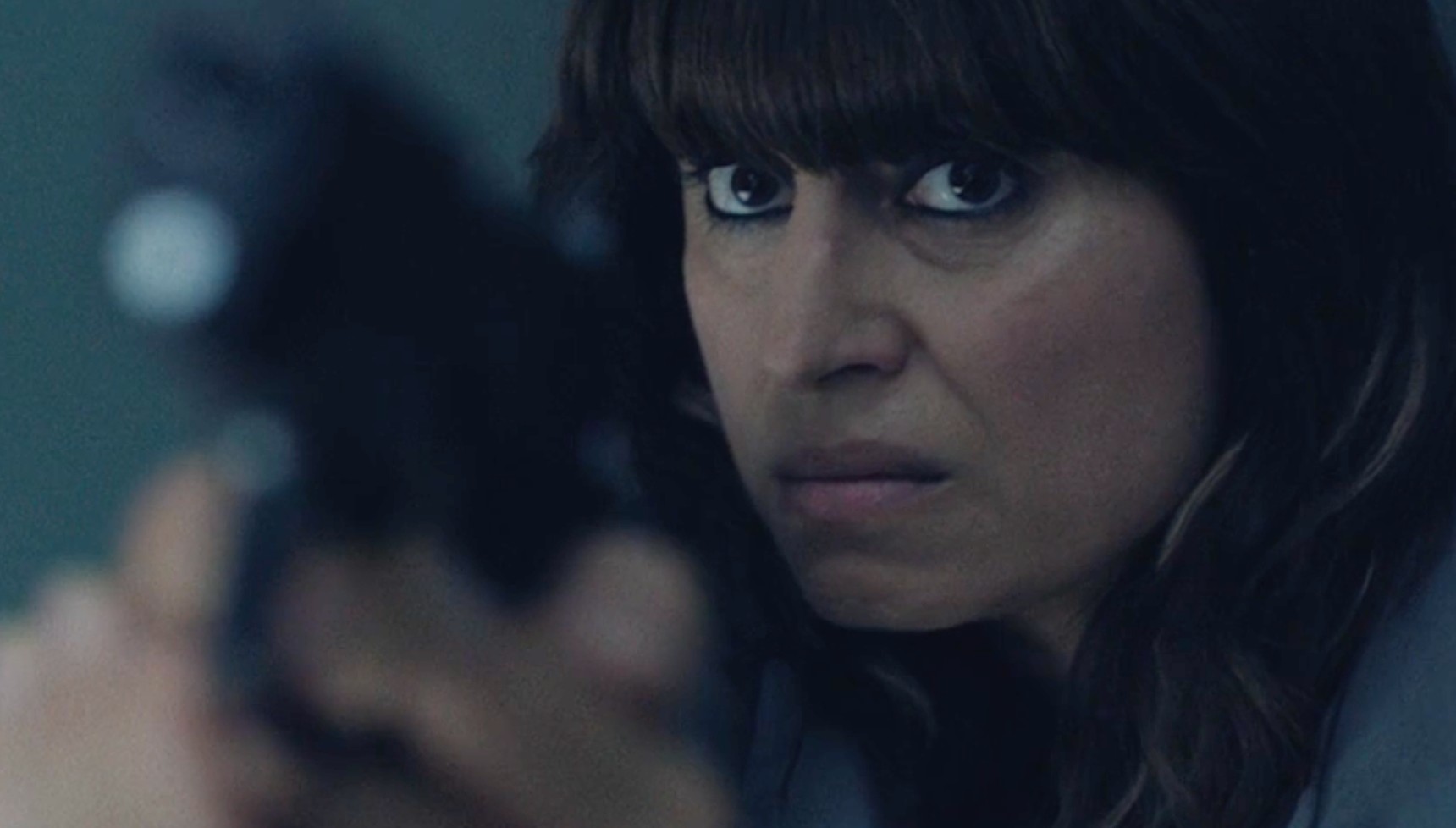 Mehreen aiming a gun at Asadi in Betrayal