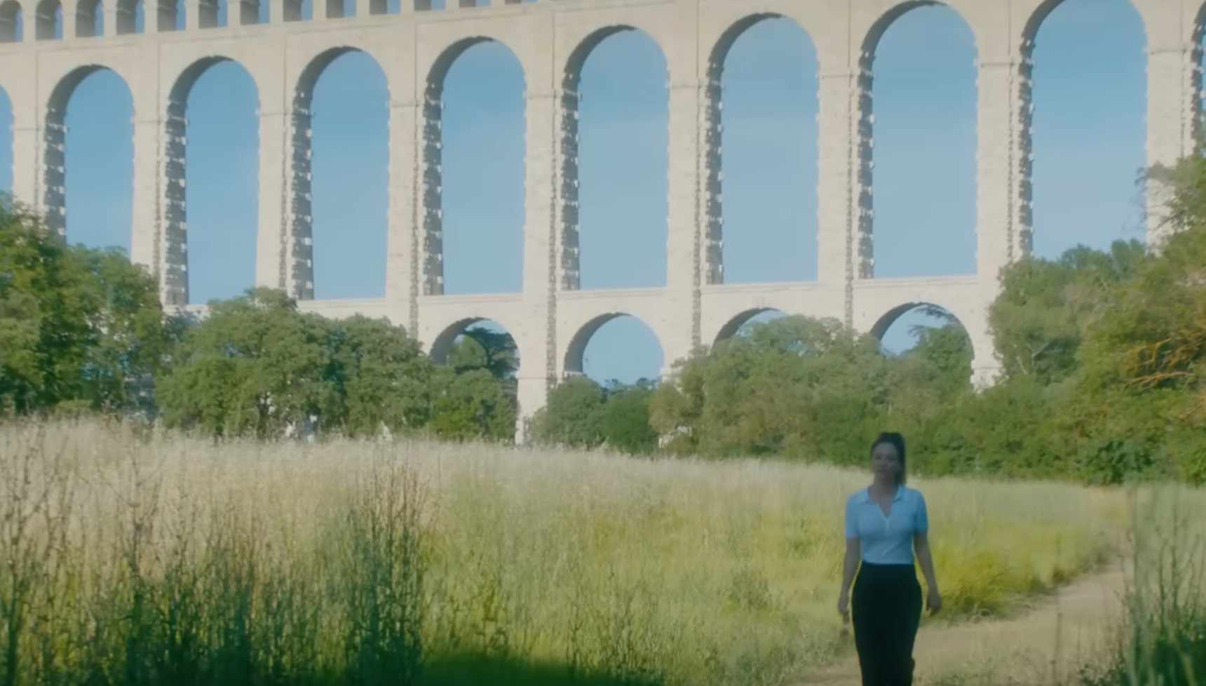 Kaley Cuoco walking in front of the Roquefavour Aqueduct in Vanished