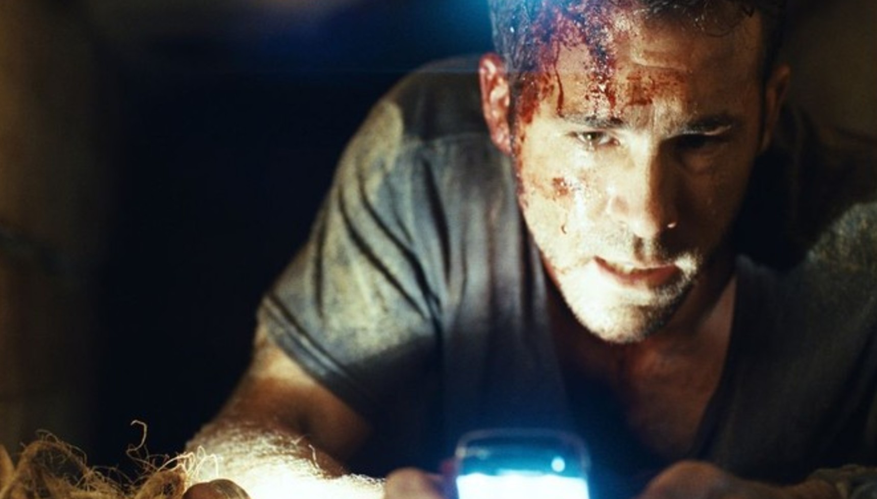 Ryan Reynolds holding a phone in Buried