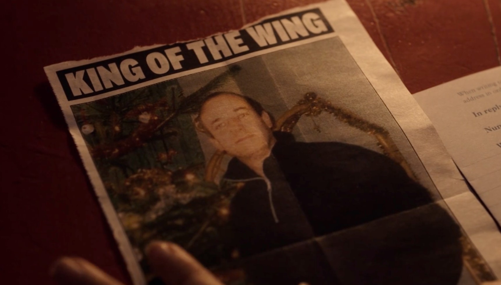 A newspaper clipping showing an unknown man as the 'King of the Wing' in The Lady