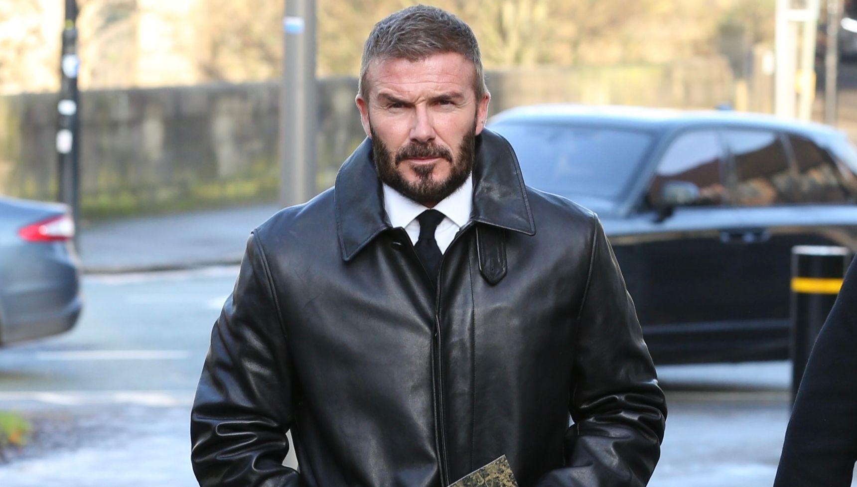 David Beckham wearing black coat walking outside 