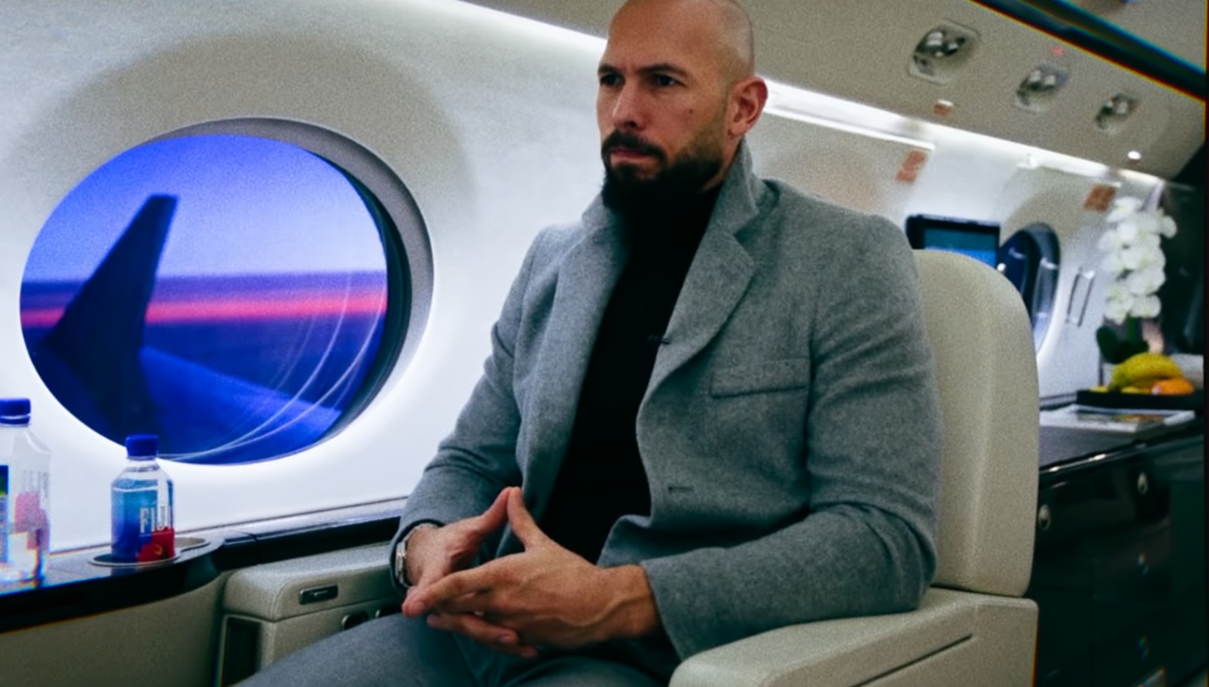 Andrew Tate holding his hands like a triangle 