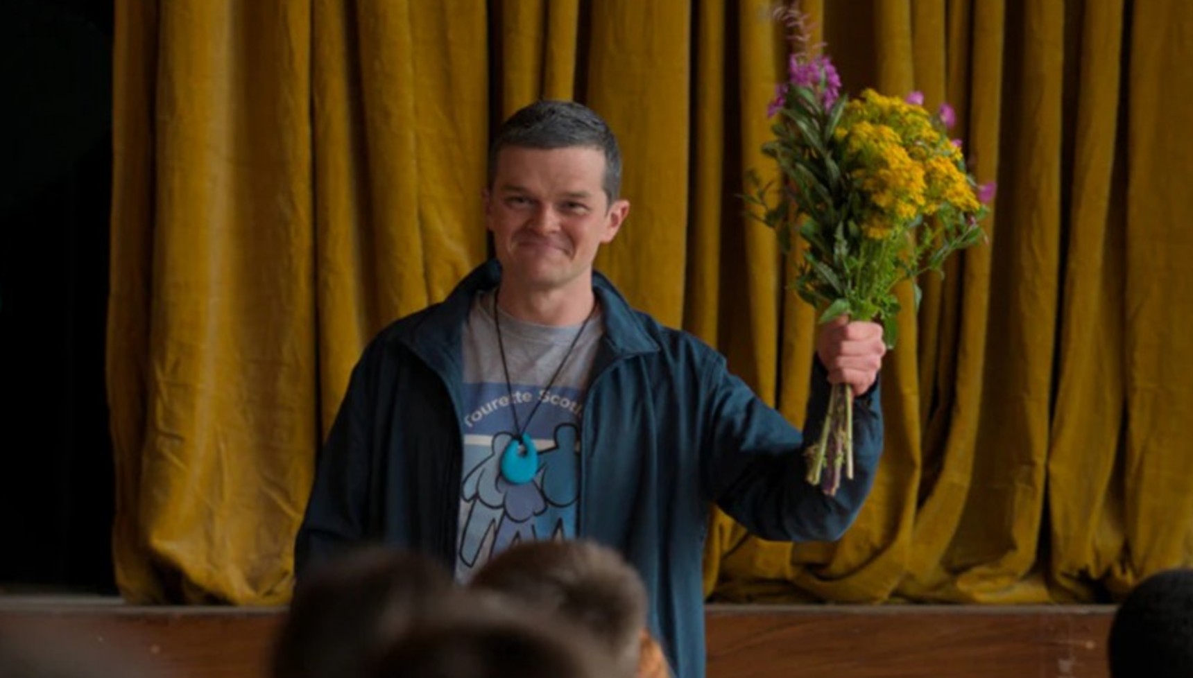 Robert Aramayo holding flowers in I Swear