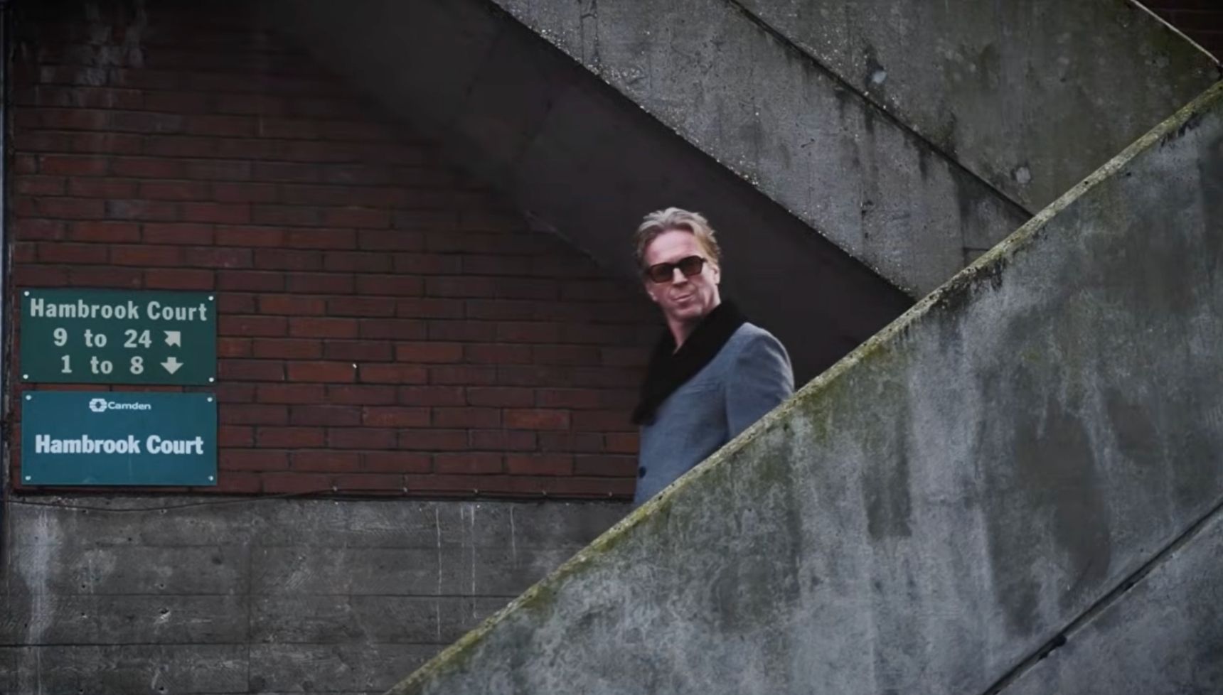 Damian lewis walking down steps in sunglasses