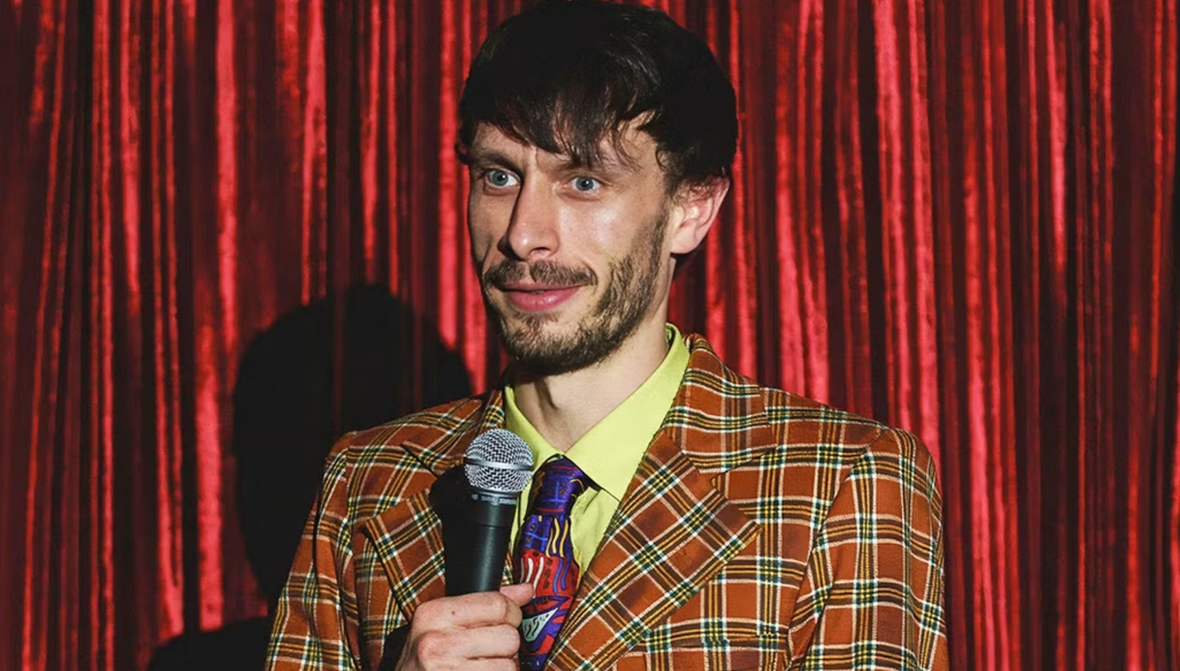 Richard Gadd holding a microphone in Baby Reindeer