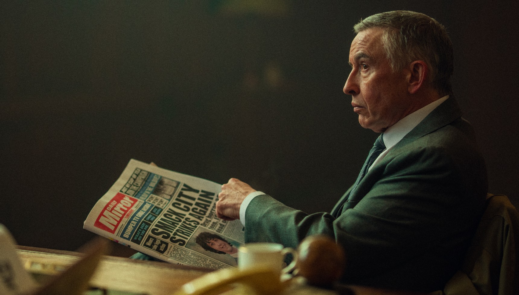 Steve Coogan reading a newspaper in Legends