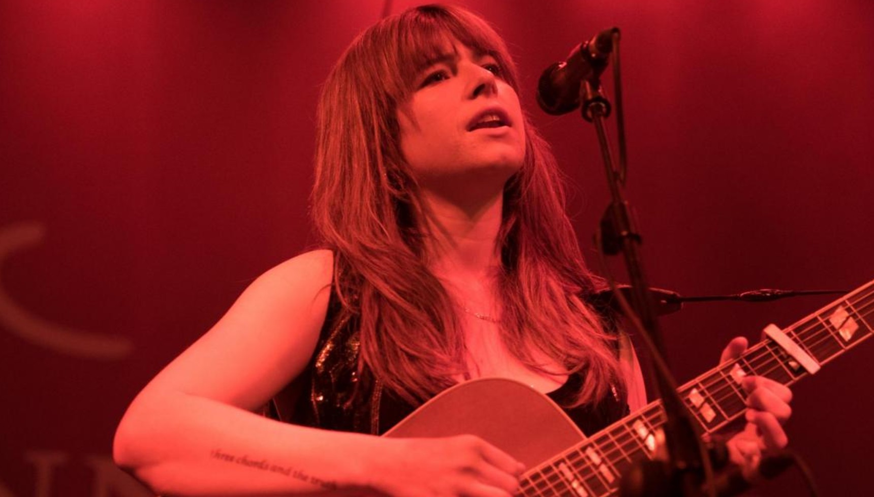 Jessie Buckley playing the guitar in Wild Rose
