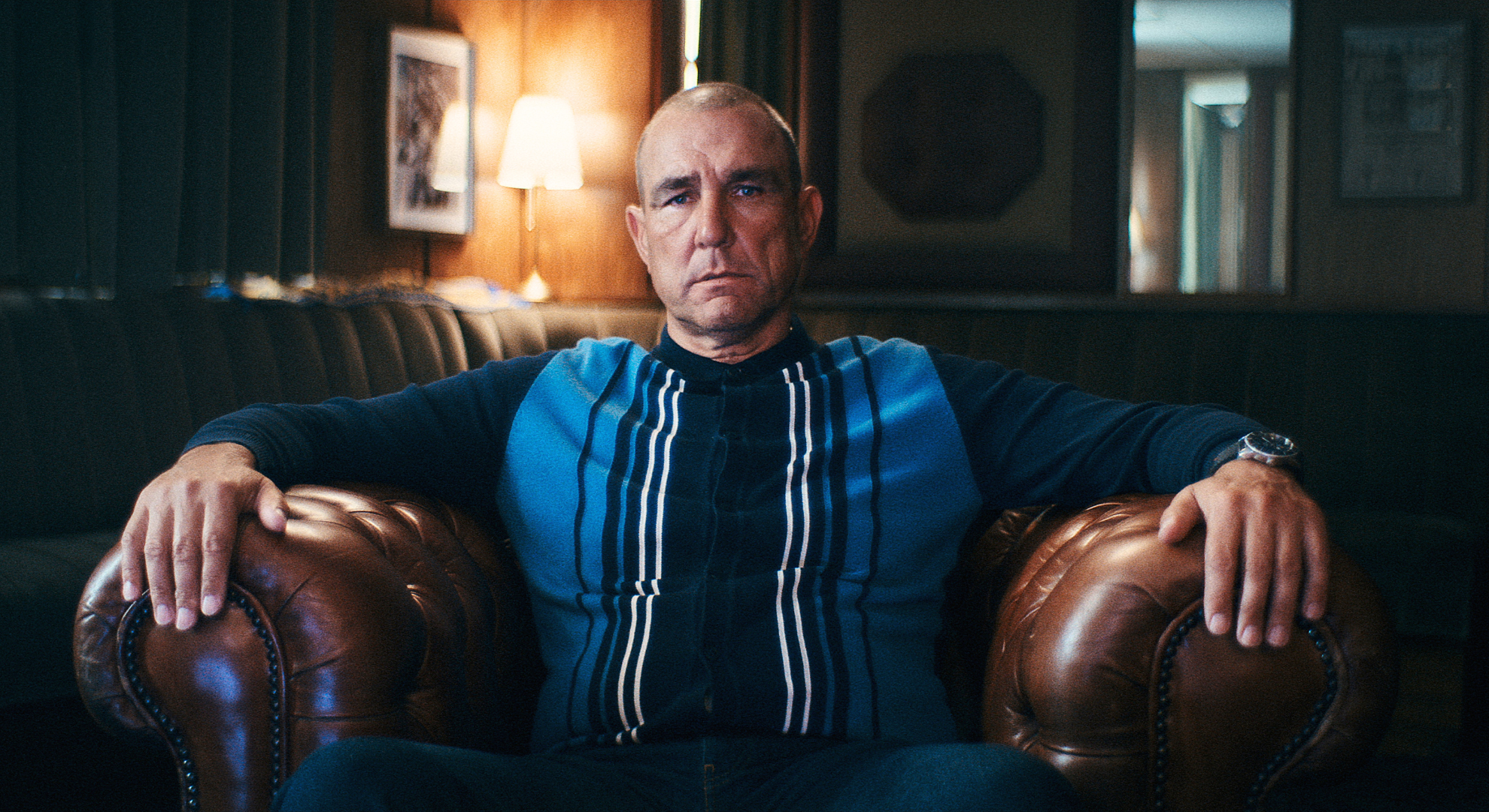Vinnie Jones sits in a leather chair