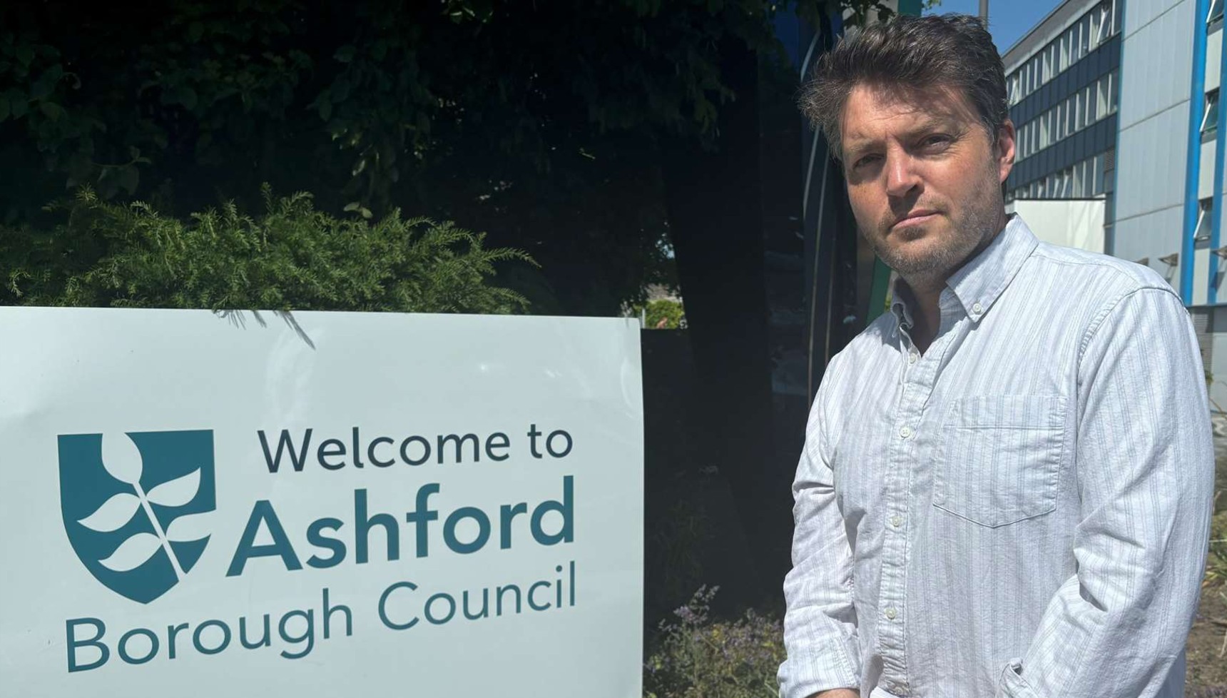 Tom Burke standing next to an Ashford Borough Council sign