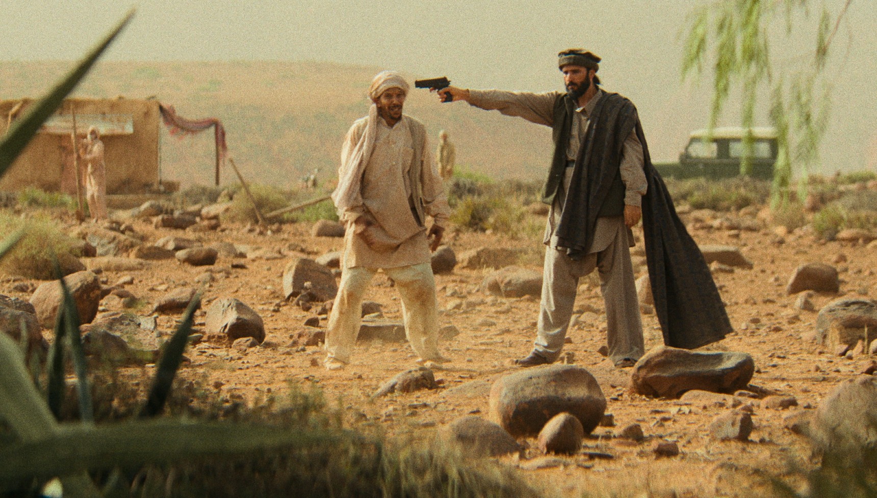 A man holding a gun at another man's head in Legends
