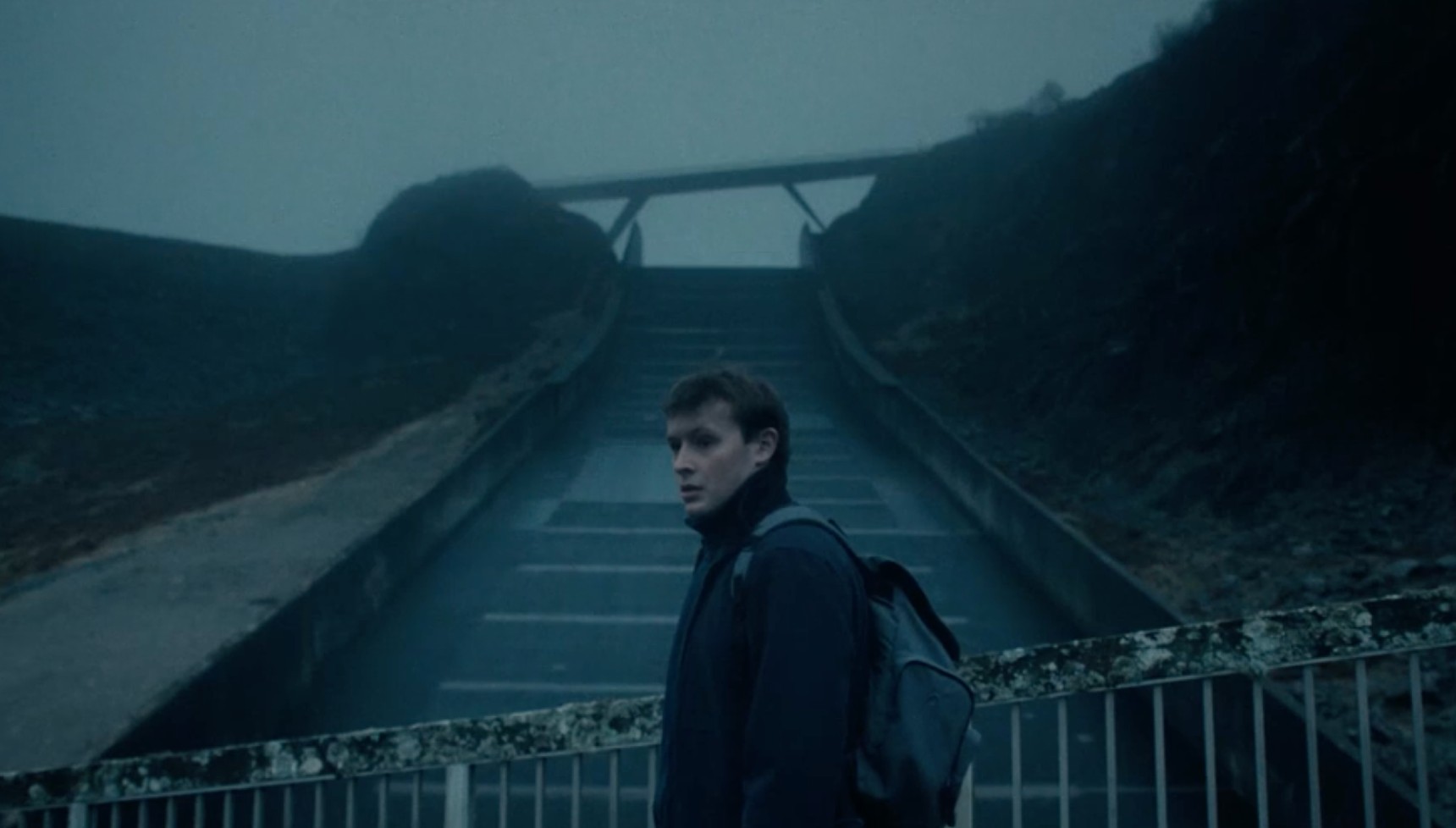 Llŷr standing in front of the reservoir in The Light in the Hall series 2