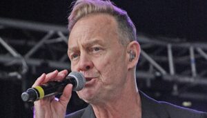 Jason Donovan singing into a microphone